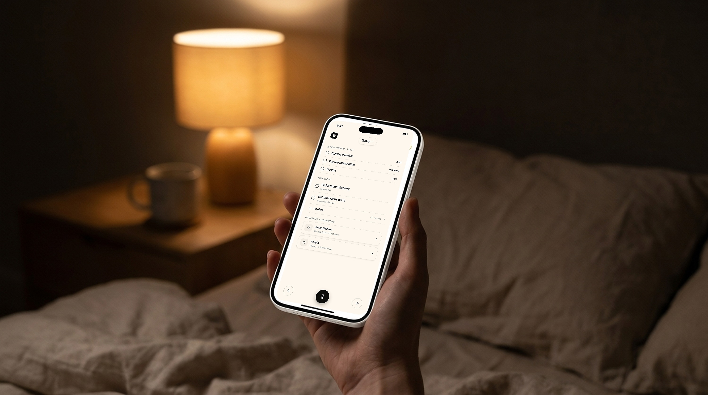 An iPhone running Oats held in a cozy dim bedroom at night, the calm Today screen glowing warmly